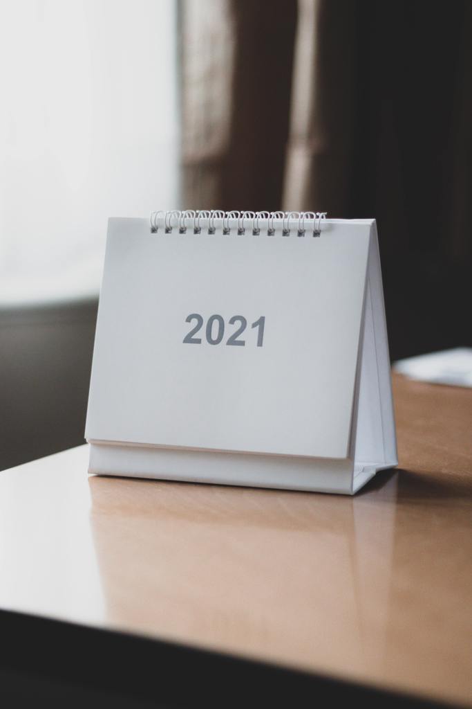 A picture of a calendar on a wooden table. The calendar says 2021. 
